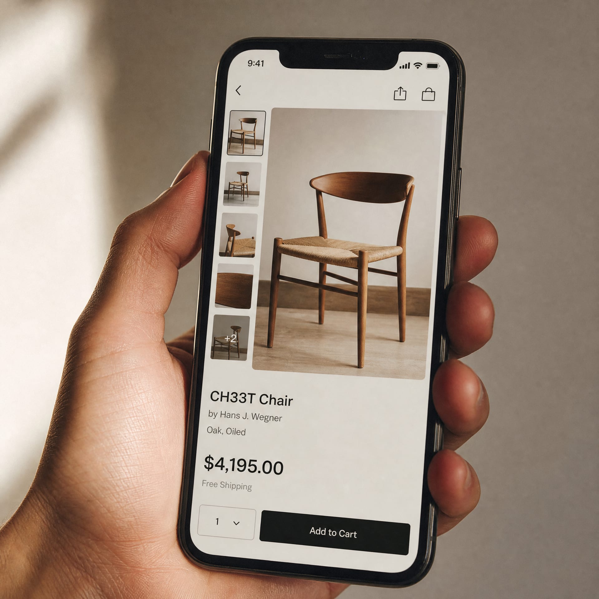 A close cinematic detail of a hand holding a phone vertically against a soft cream background, the screen showing an Amazon product detail page with the image thumbnail strip and the price block visible.