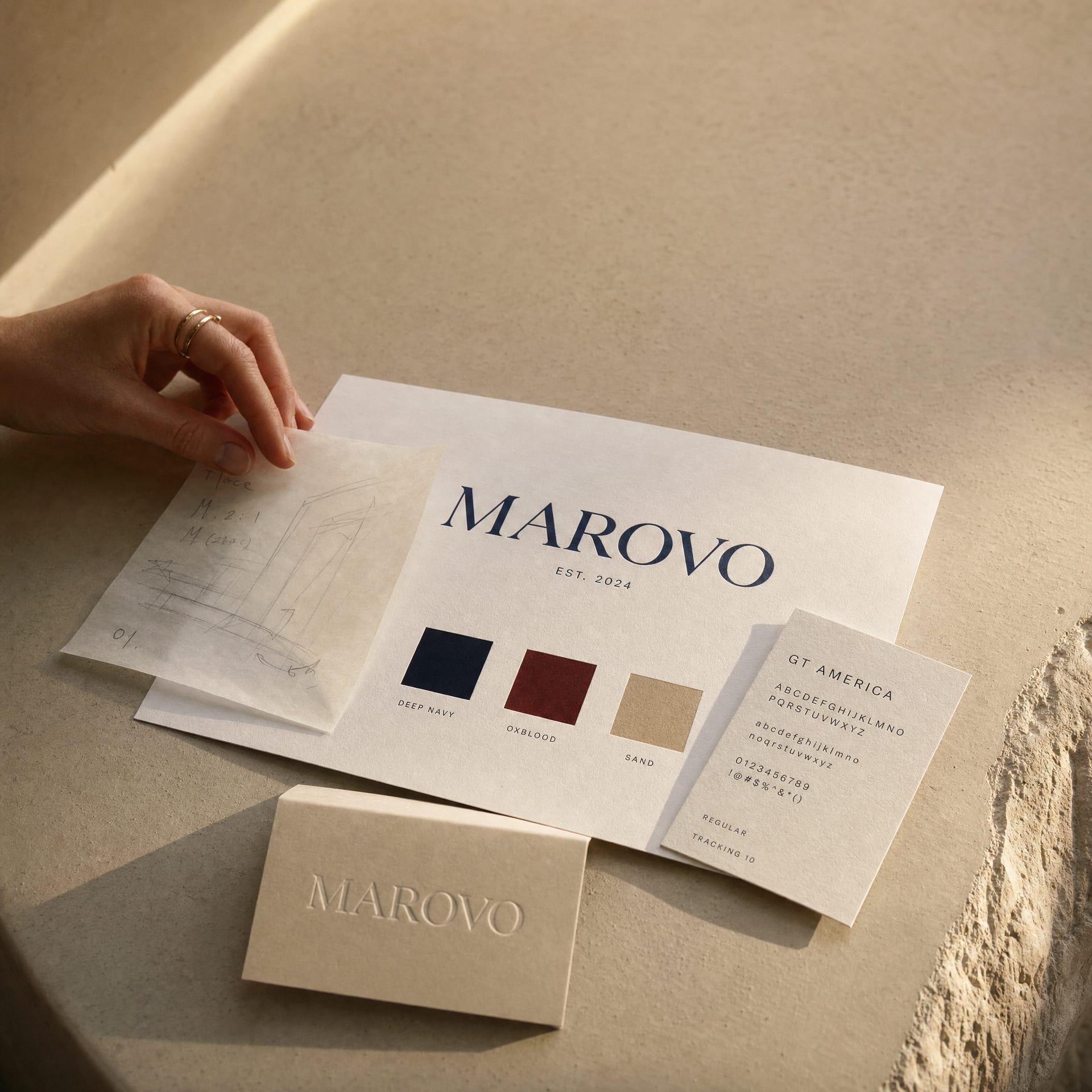 A printed brand identity board on a warm plaster ledge.