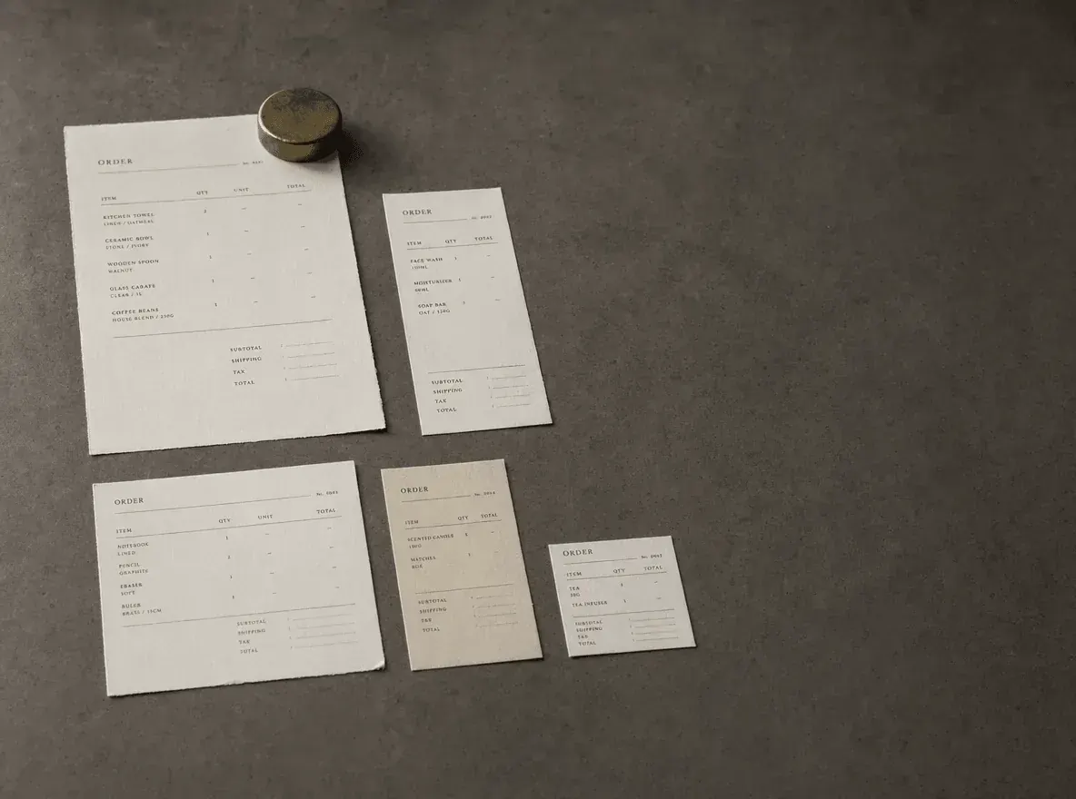 A concrete worktable covered with finished printed brand materials laid out in a loose grid