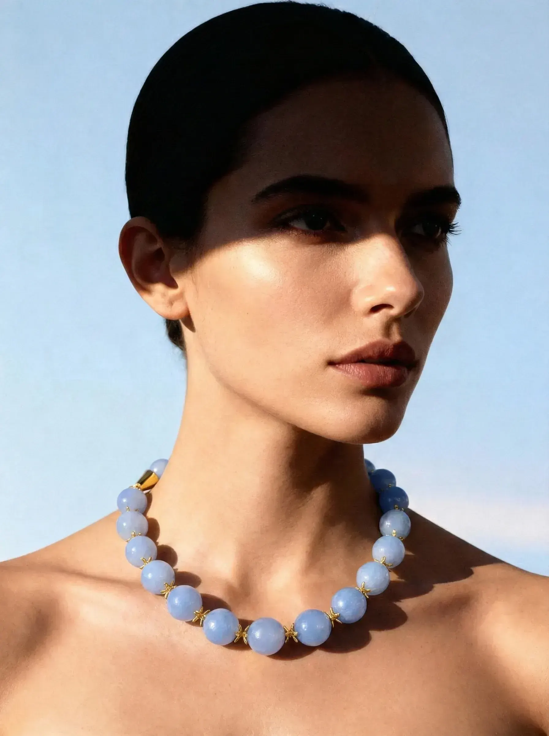 A model wearing a statement piece from the heritage British jeweller, photographed in soft directional light.